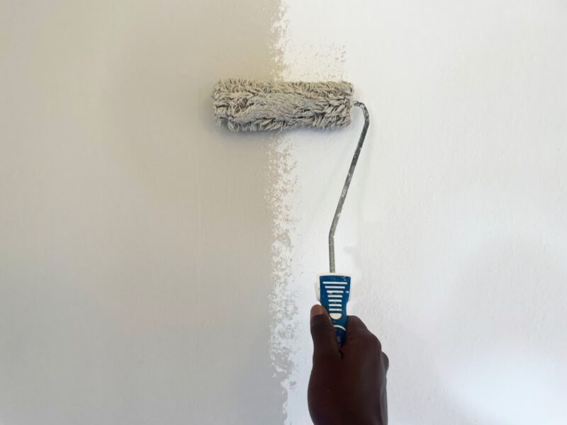 An African painter working on the wall.
